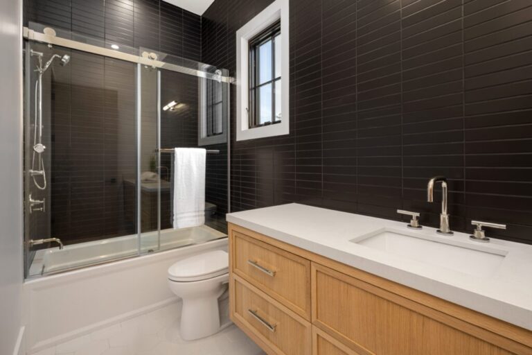 Modern bathroom with black tiles and wooden vanity