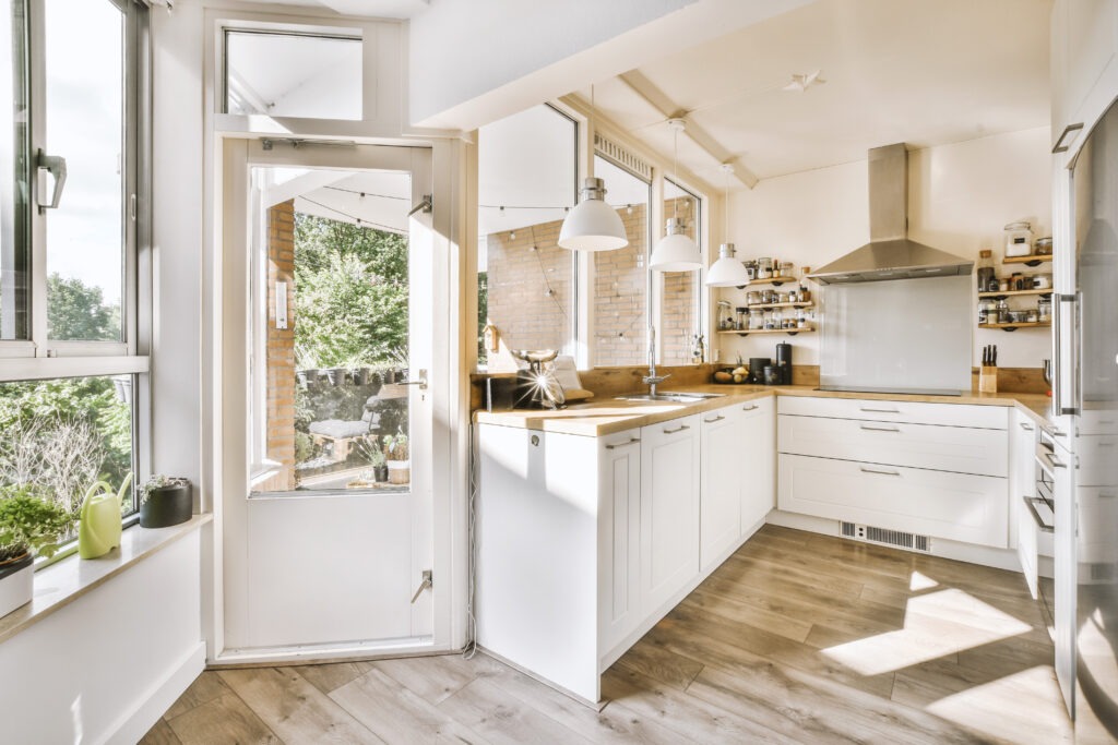 Corner cupboards and table with chairs located in light kitchen of contemporary flat