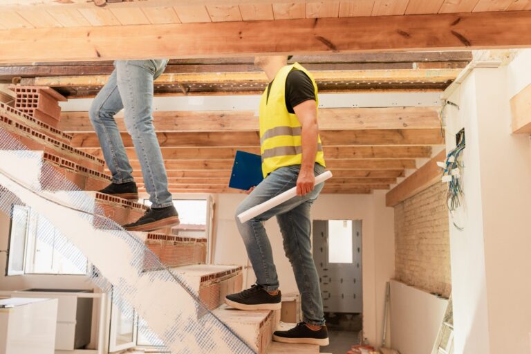 Construction workers and engineer climbing brick staircase in building under construction