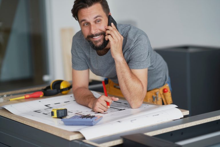 Smiling carpenter talking to a client on the phone